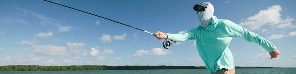 An angler slides a fly rod out of a car-top holder.