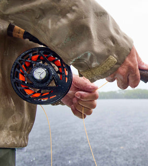 A close-up of an angler's hands holding a new Helios rod outfitted with .