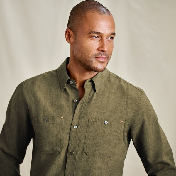 Man wearing a green shirt against a beige background