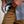 Load image into Gallery viewer, Person cleaning sunglasses with a cloth against a neutral background