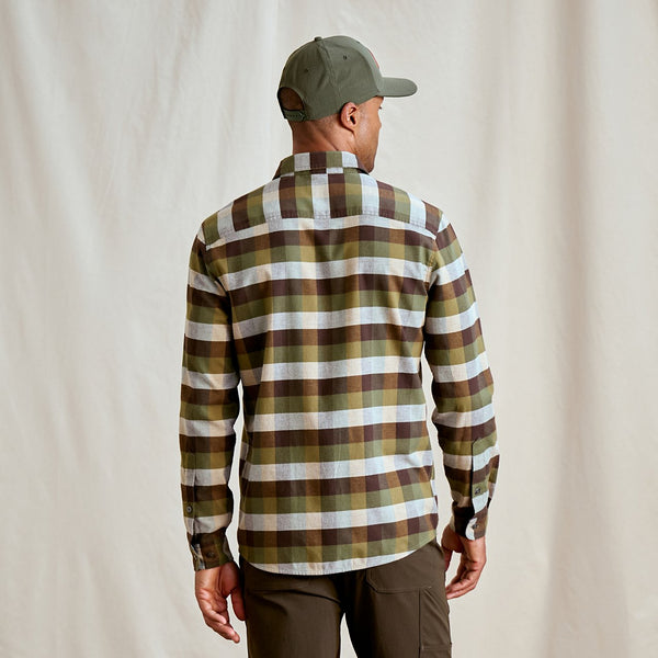 Man wearing a plaid shirt and cap from behind on a plain background