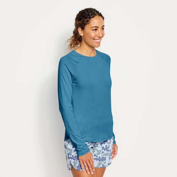woman modelling blue Orvis sweater and blue camouflage shorts