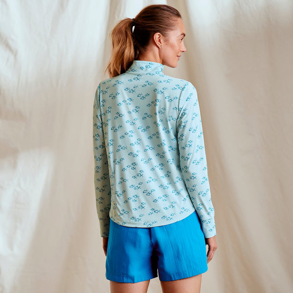 woman with her back to the camera wearing light blue hoodie and blue shorts