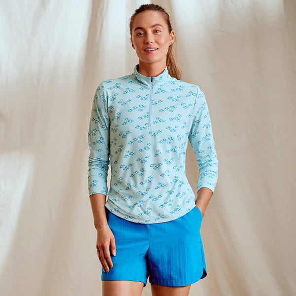woman wearing light blue half zipped sweater and blue shorts