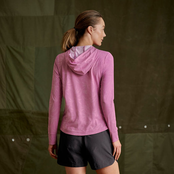 woman with er back to the camera wearing pink hoodie and black shorts