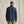 Load image into Gallery viewer, Man wearing a navy jacket and green pants against a beige background