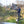 Load image into Gallery viewer, A person fly fishing in a river, standing on a wooden platform