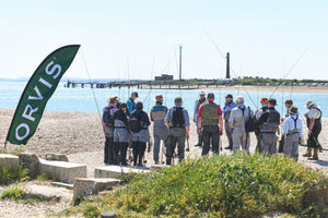 large group of fly fishers on riverbank