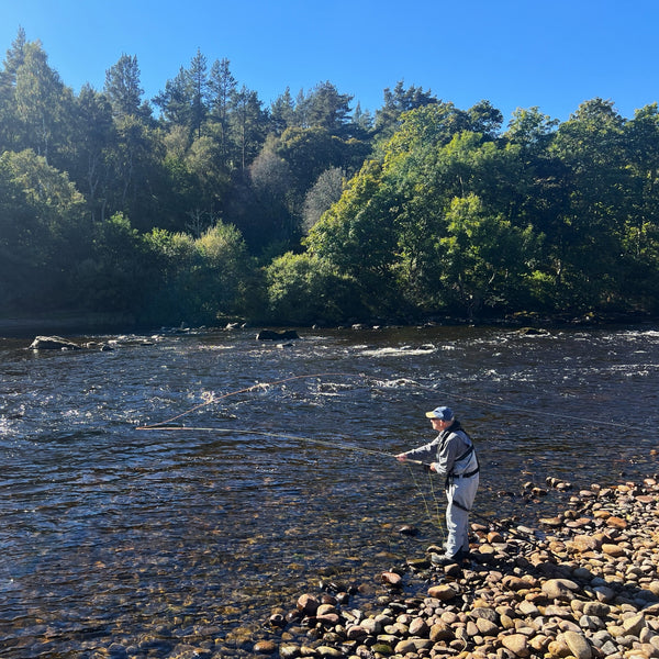 man fly fishing on river bank