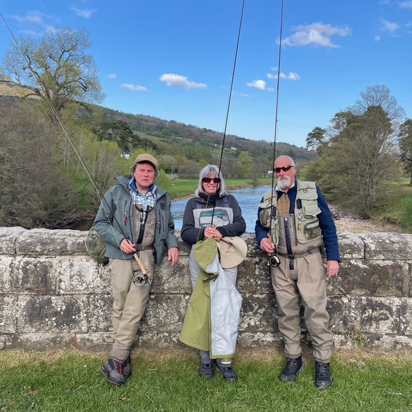 two men and one woman fly fishers on bridge