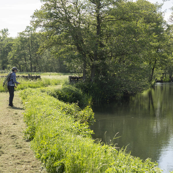 man on side of river in the sunshine
