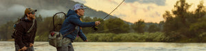 Two anglers fly fish under low clouds and mist