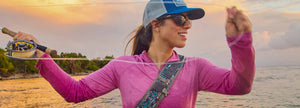 An angler wearing a magenta hoodie casts her line