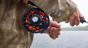close-up of an Orvis Mirage fly reel in use on a rainy day