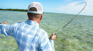 An angler's Helios rod bends as they fish the ocean shallows