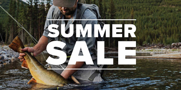 Summer Sale. An angler kneels in the river, holding their catch.