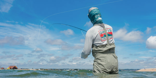 man wearing waders fly fishing
