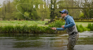 Man fly fishing in a river with 'HELIOS' branding above him.