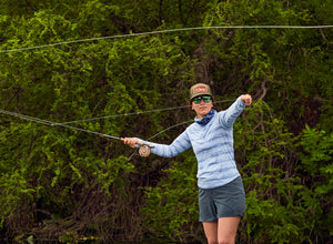 An angler casts her line