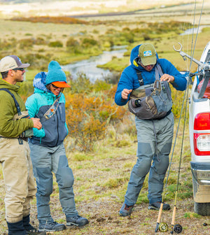 Three anglers preparing for the day alongside their truck