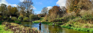 A wading angler casts their line in Itchen beat