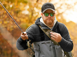 An angler wearing zip waders extends their fly rod whilst Euro-nymphing