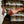 Load image into Gallery viewer, Person wearing a plaid shirt holding a mask with a neutral background
