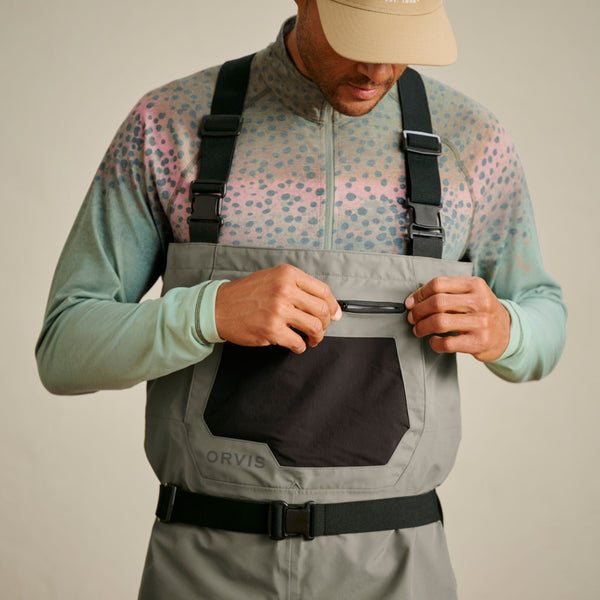 man closing zipper on waders