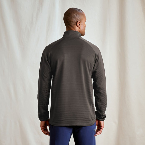 Person wearing a dark gray long-sleeve shirt against a plain background