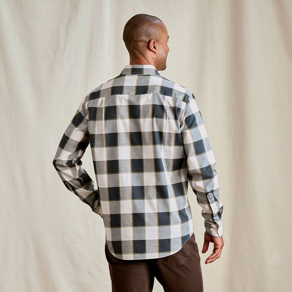 Man wearing a black and white checkered shirt against a beige background