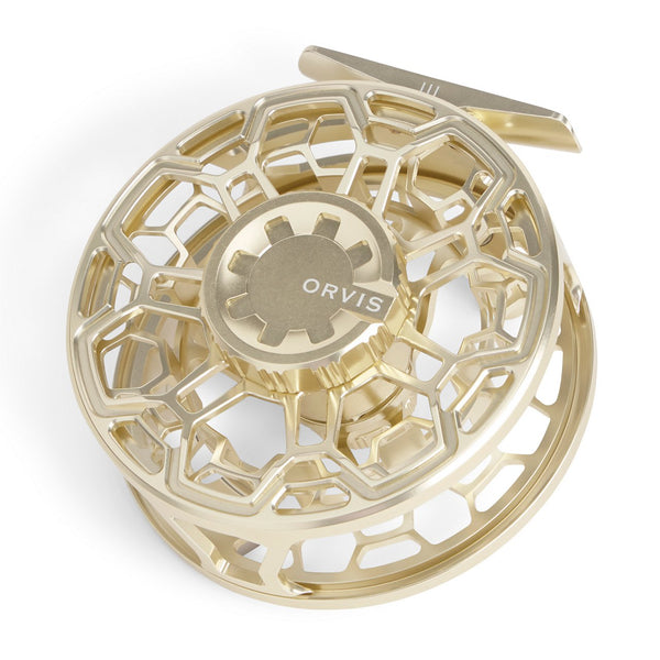 gold fly reel from Orvis on white background