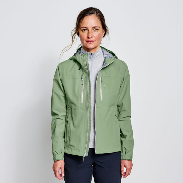 woman wearing green waterproof jacket and dark blue pants