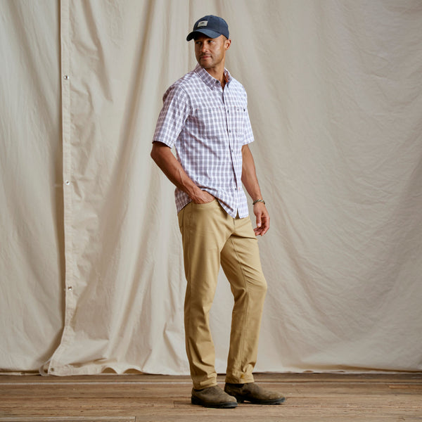 Man modelling blue cap, white shirt and beige pants