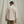 Load image into Gallery viewer, Man with his back to the camera wearing beige and white checkered shirt and black cap in front of beige background
