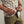 Load image into Gallery viewer, Man cleaning sunglasses on the bottom of beige, blue and white checkered shirt.
