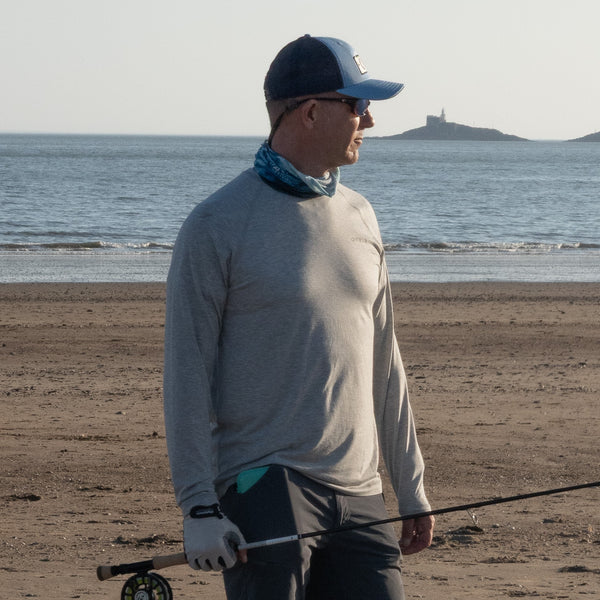 man hlding fly rod on river bank