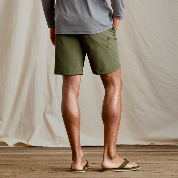 man wearing dark green shorts and flip flops