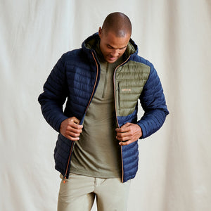 man wearing blue jacket and green half zipped jumper