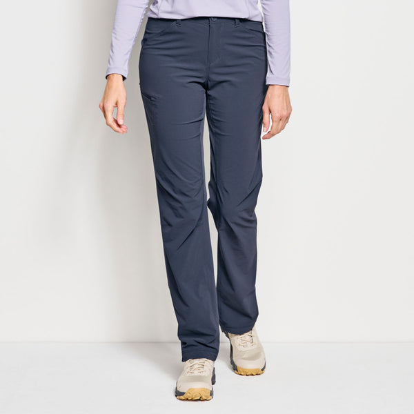woman walking towards camera in dark blue pants