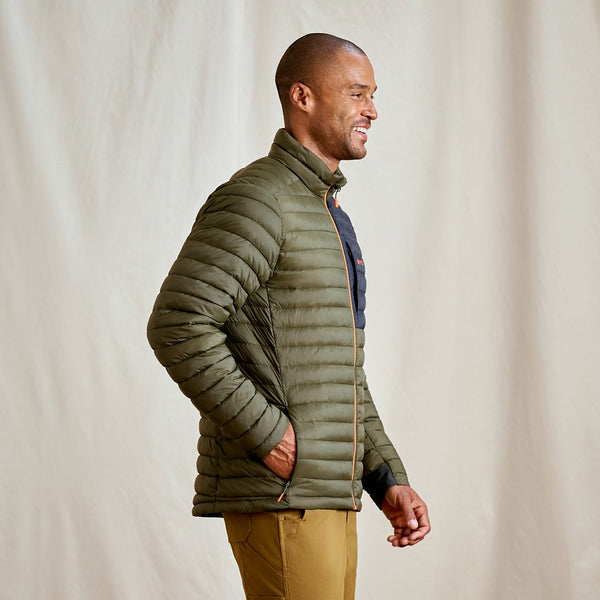 man wearing dark green jacket and smiling