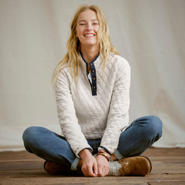 woman sat on wooden floor smiling