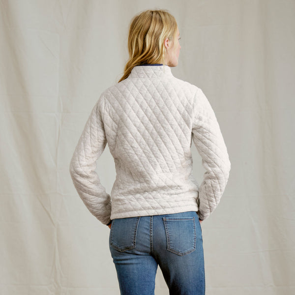 woman facing away from camera in white sweater and jeans