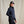 Load image into Gallery viewer, Woman wearing a navy jacket and cap against a beige background
