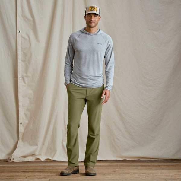 man modelling Orvis cap, light blue long sleeved t-shirt and dark green trousers