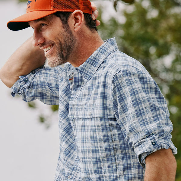 man smiling wearing orange cap and blue and white shirt