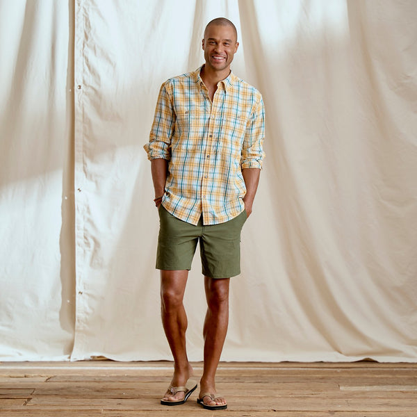 man smiling to the camera wearing checkered short and green shorts