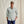 Load image into Gallery viewer, Man wearing a light grey button-up shirt and navy pants with a cap on a beige background

