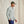 Load image into Gallery viewer, Man wearing a light grey shirt and green cap against a beige background
