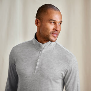 Man wearing a gray quarter-zip pullover against a neutral background