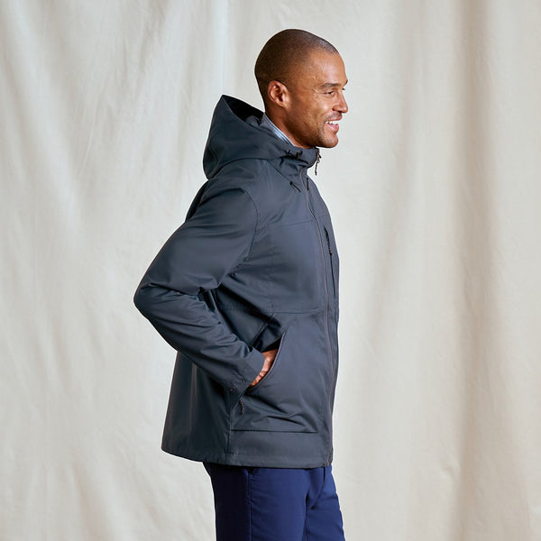 Man wearing a dark blue jacket against a plain background